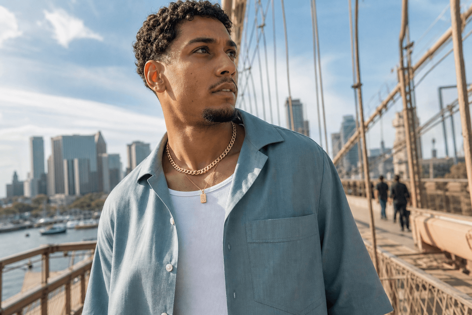 Person wearing solid gold Cuban link and pendant in soft everyday light.